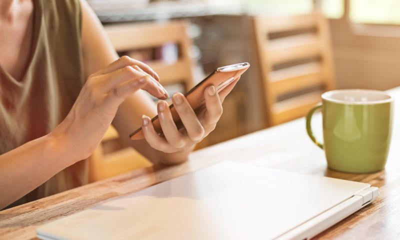 スマホを触っている女性の手の写真