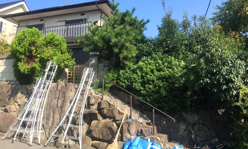 空き家の庭のお手入れをしている庭師の写真
